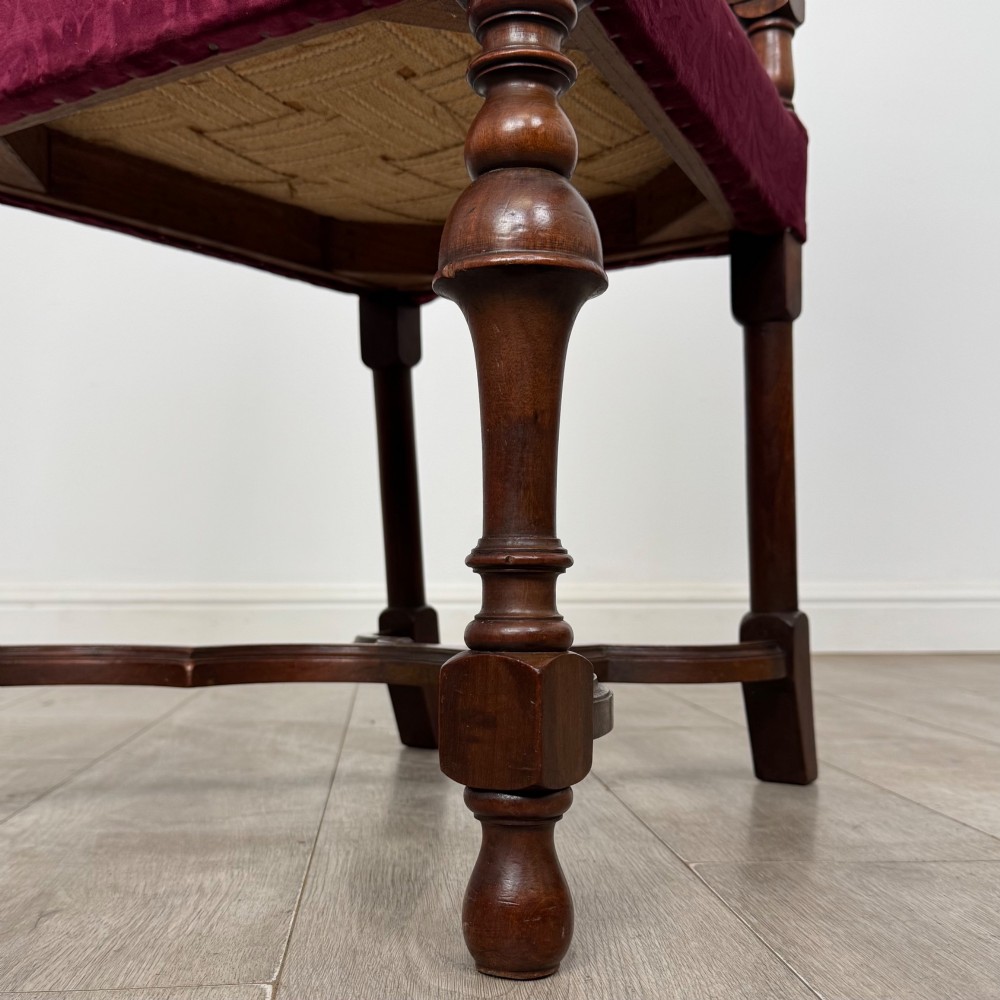 A set of mahogany dining chairs featuring high cane-panelled backs, carved top crests, turned legs, and deep red velvet seats. View VII