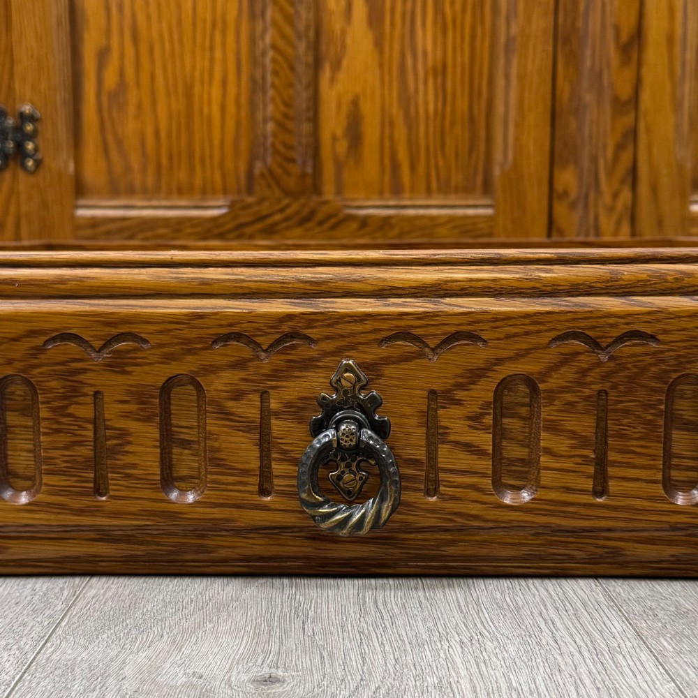 A three-door golden oak sideboard featuring three carved drawers, panelled cabinet doors, and metal drop handles. View XII