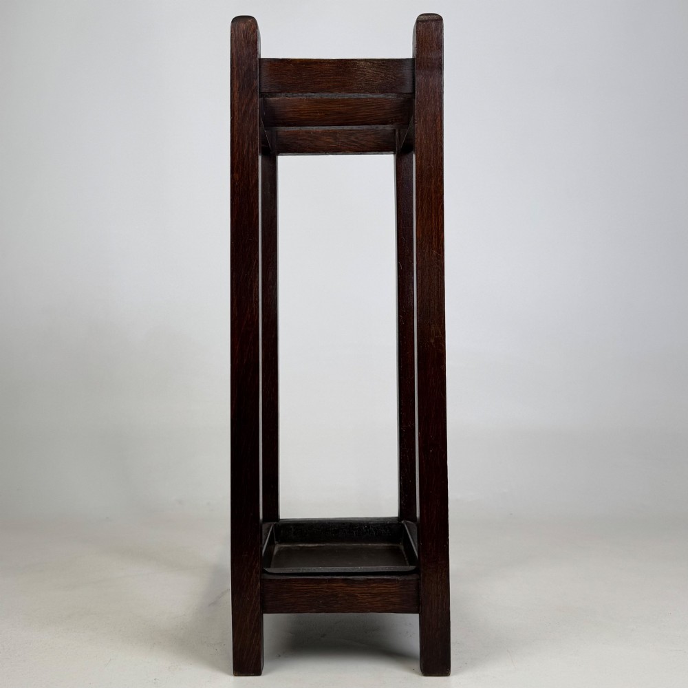 A small dark oak Edwardian umbrella stand featuring a square wooden frame with an upper section divider and a metal drip tray at the base. View III