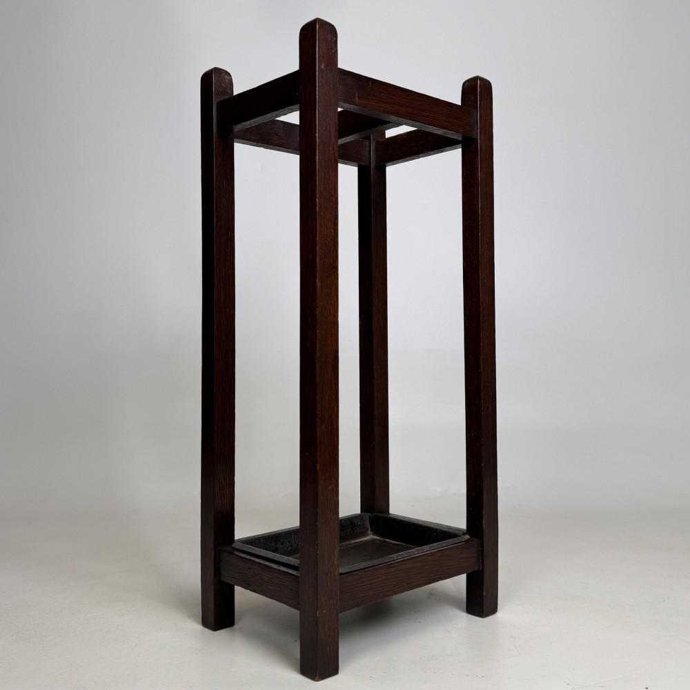 A small dark oak Edwardian umbrella stand featuring a square wooden frame with an upper section divider and a metal drip tray at the base. View IV