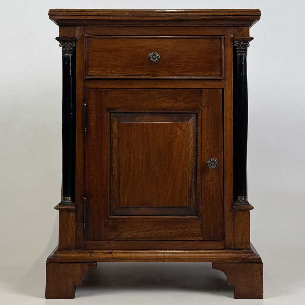 A pair of matching mahogany bedside cabinets with single top drawers, panelled cupboard doors, and black ebonised side columns. View II