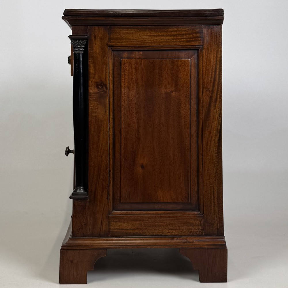 A pair of matching mahogany bedside cabinets with single top drawers, panelled cupboard doors, and black ebonised side columns. View V