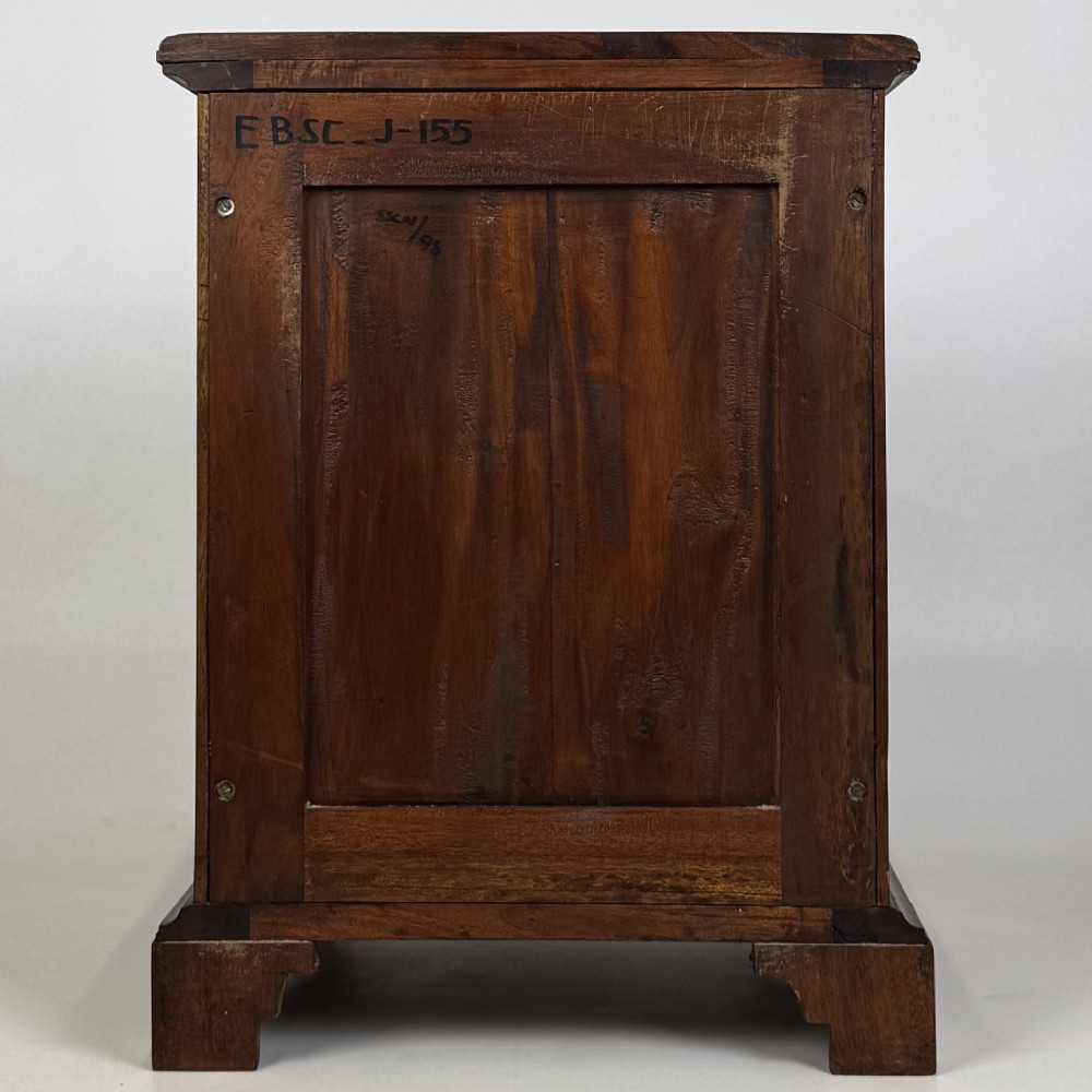 A pair of matching mahogany bedside cabinets with single top drawers, panelled cupboard doors, and black ebonised side columns. View VII