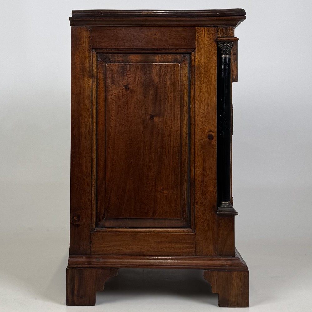 A pair of matching mahogany bedside cabinets with single top drawers, panelled cupboard doors, and black ebonised side columns. View IX