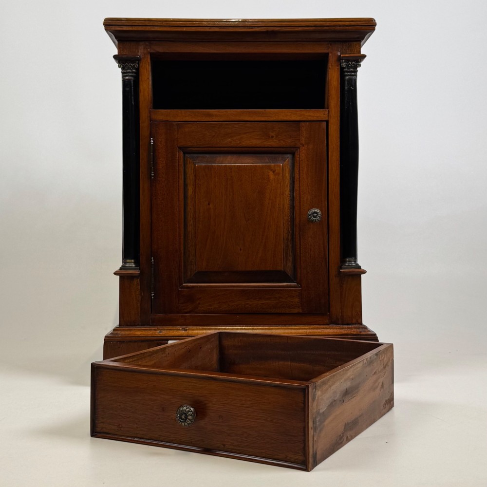 A pair of matching mahogany bedside cabinets with single top drawers, panelled cupboard doors, and black ebonised side columns. View XI