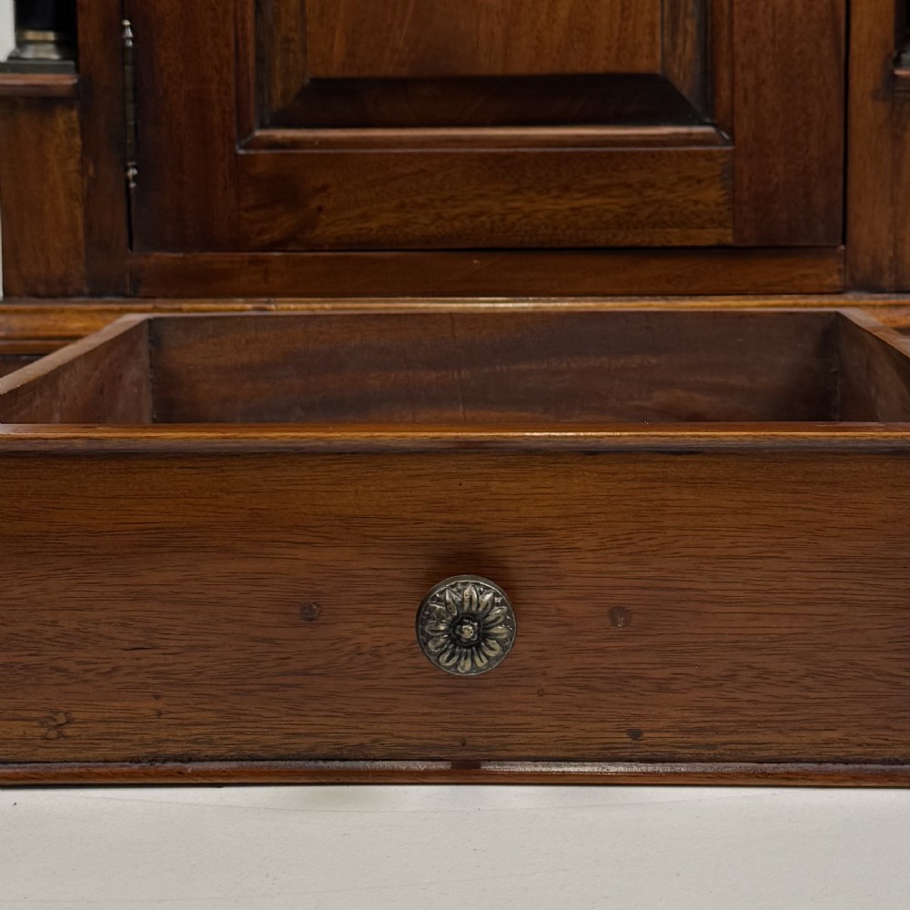 A pair of matching mahogany bedside cabinets with single top drawers, panelled cupboard doors, and black ebonised side columns. View XII