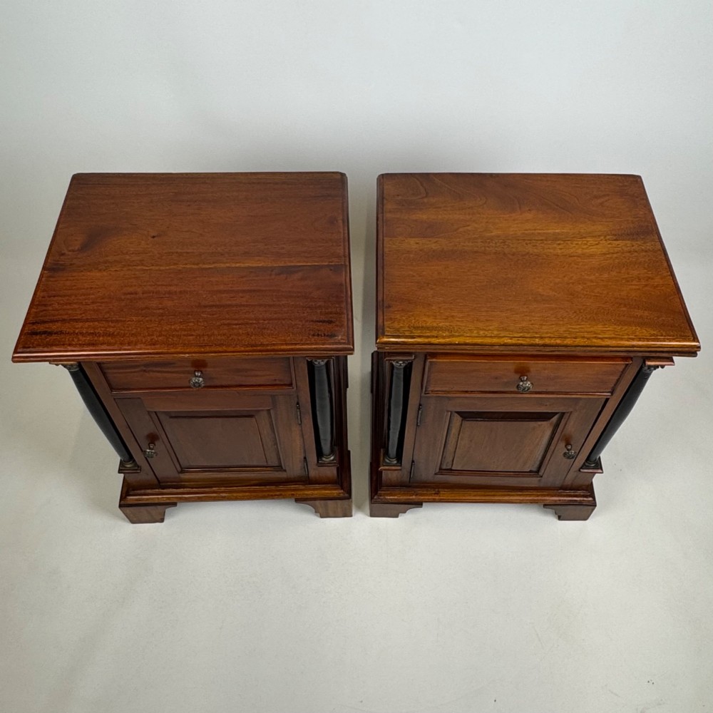 A pair of matching mahogany bedside cabinets with single top drawers, panelled cupboard doors, and black ebonised side columns. View XIII