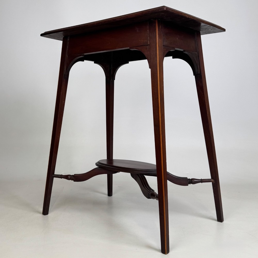 An Edwardian mahogany side table featuring a square top, splayed legs, corner spandrels, and a central circular undertier supported by shaped stretchers. View II