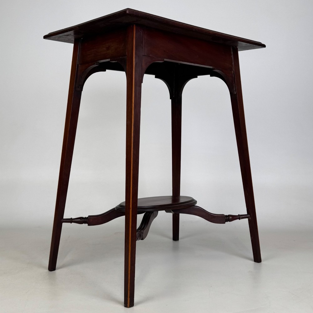 An Edwardian mahogany side table featuring a square top, splayed legs, corner spandrels, and a central circular undertier supported by shaped stretchers. View VIII