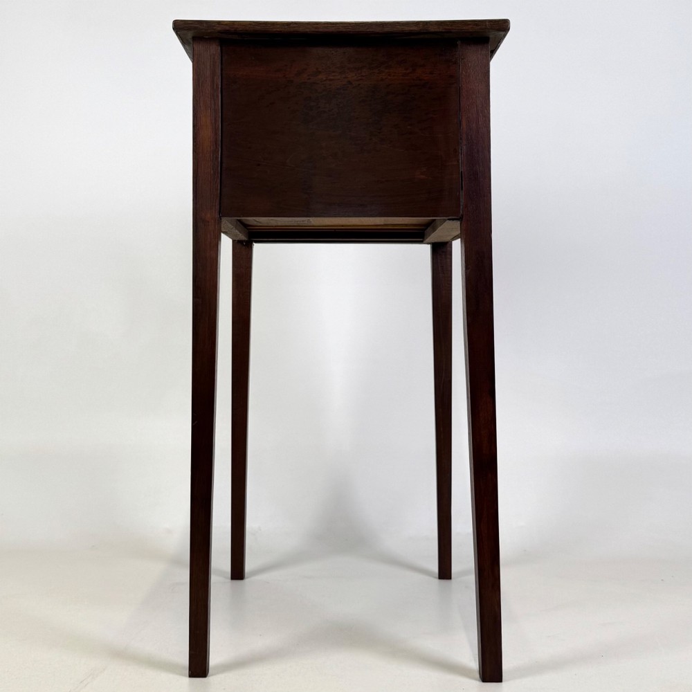 An antique dark mahogany side table featuring two stacked drawers with circular handles, supported by tall tapered square legs. View III