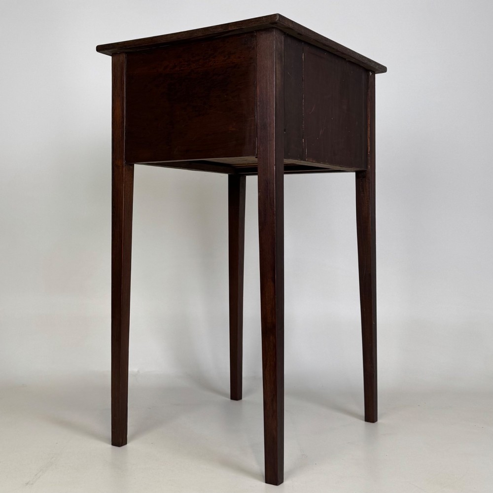 An antique dark mahogany side table featuring two stacked drawers with circular handles, supported by tall tapered square legs. View IV