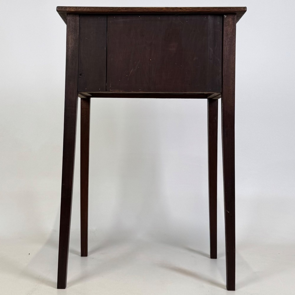 An antique dark mahogany side table featuring two stacked drawers with circular handles, supported by tall tapered square legs. View V
