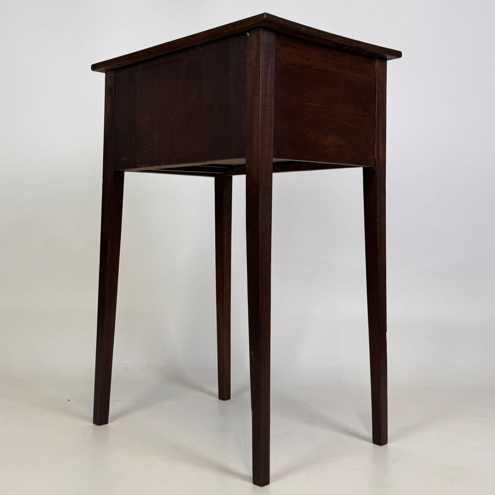 An antique dark mahogany side table featuring two stacked drawers with circular handles, supported by tall tapered square legs. View VI