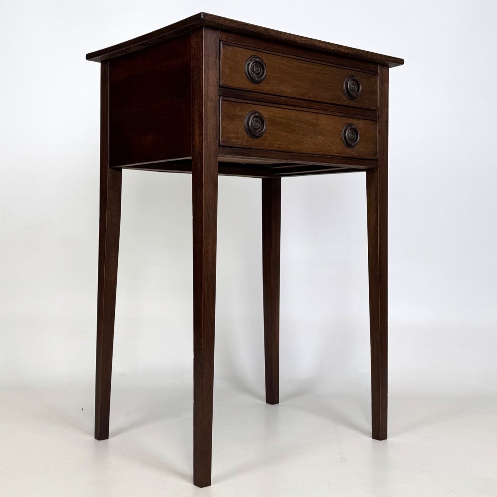An antique dark mahogany side table featuring two stacked drawers with circular handles, supported by tall tapered square legs. View VIII