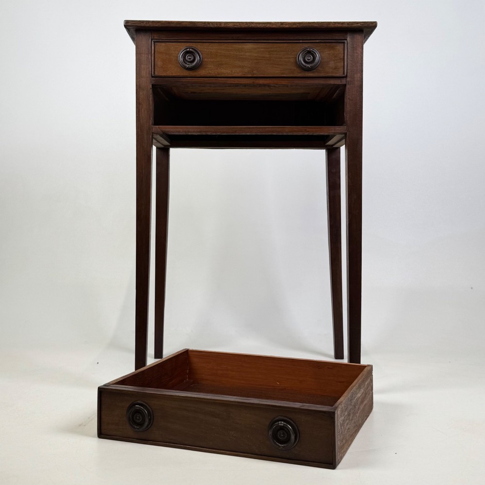 An antique dark mahogany side table featuring two stacked drawers with circular handles, supported by tall tapered square legs. View X