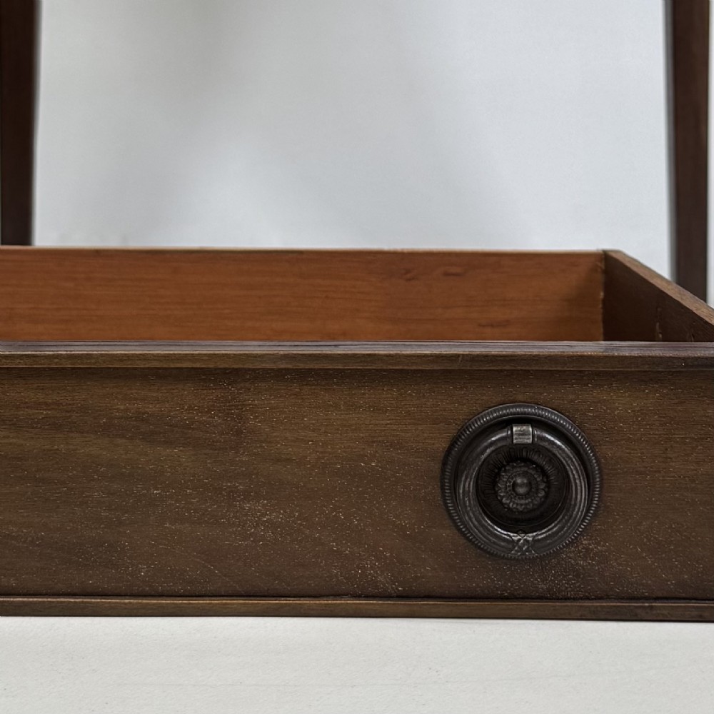 An antique dark mahogany side table featuring two stacked drawers with circular handles, supported by tall tapered square legs. View XI