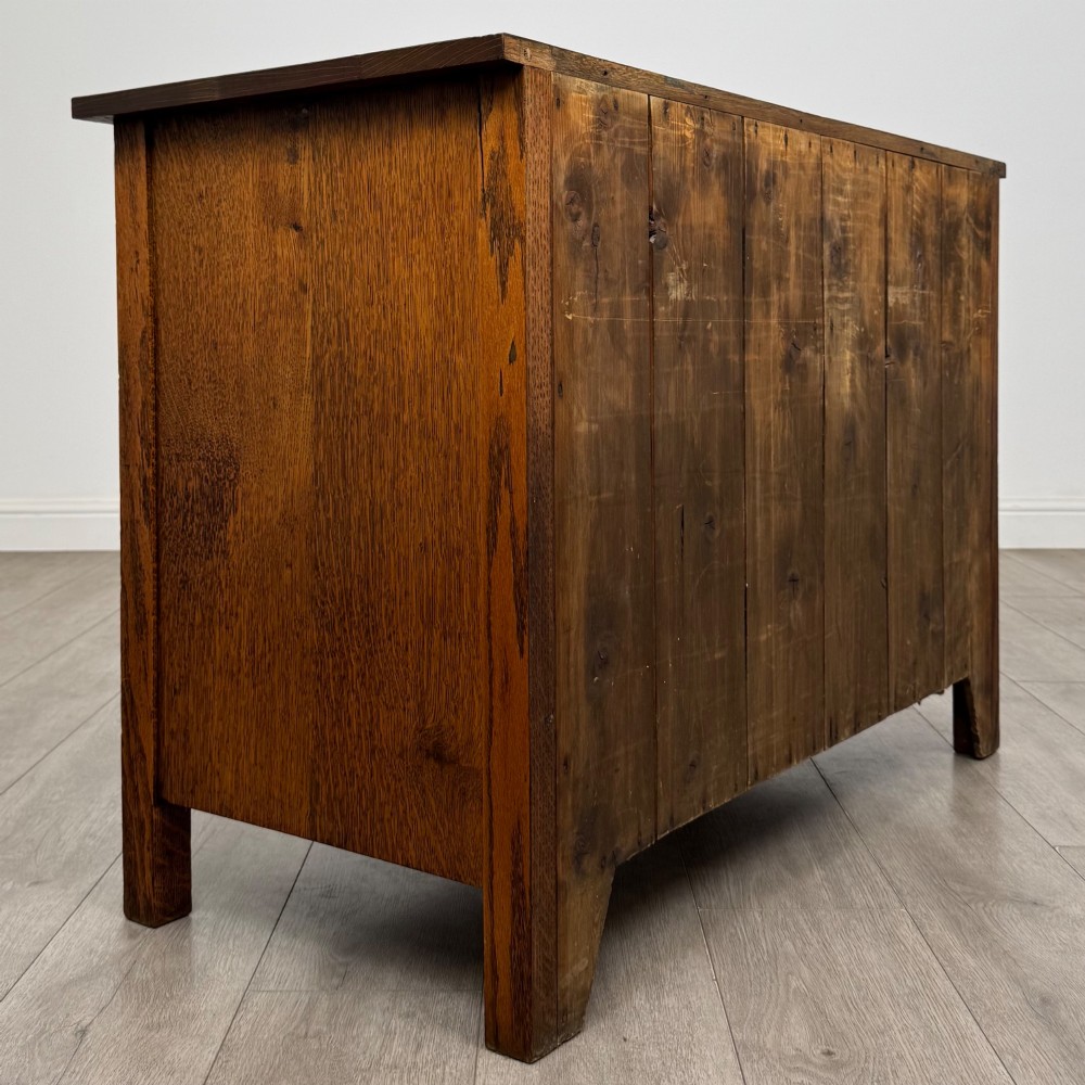 An antique Arts and Crafts oak chest of drawers featuring two short drawers over two full-width drawers with iron drop-ring handles on square backplates. View IV