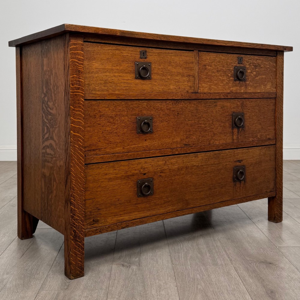 An antique Arts and Crafts oak chest of drawers featuring two short drawers over two full-width drawers with iron drop-ring handles on square backplates. View VIII