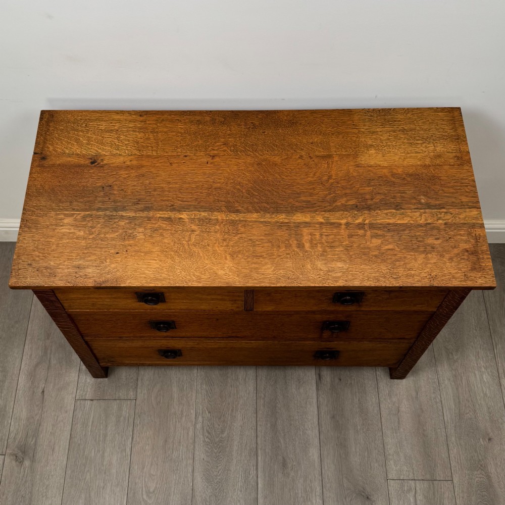 An antique Arts and Crafts oak chest of drawers featuring two short drawers over two full-width drawers with iron drop-ring handles on square backplates. View IX