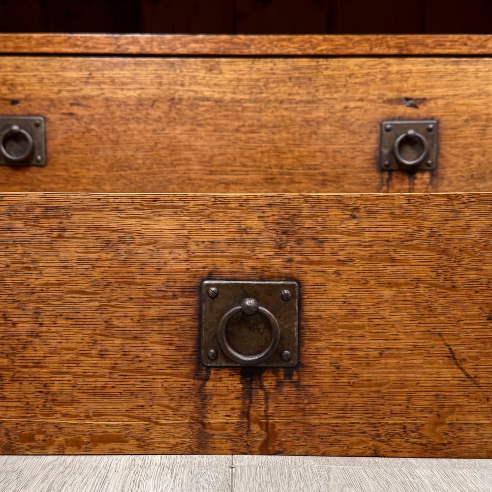 An antique Arts and Crafts oak chest of drawers featuring two short drawers over two full-width drawers with iron drop-ring handles on square backplates. View XI