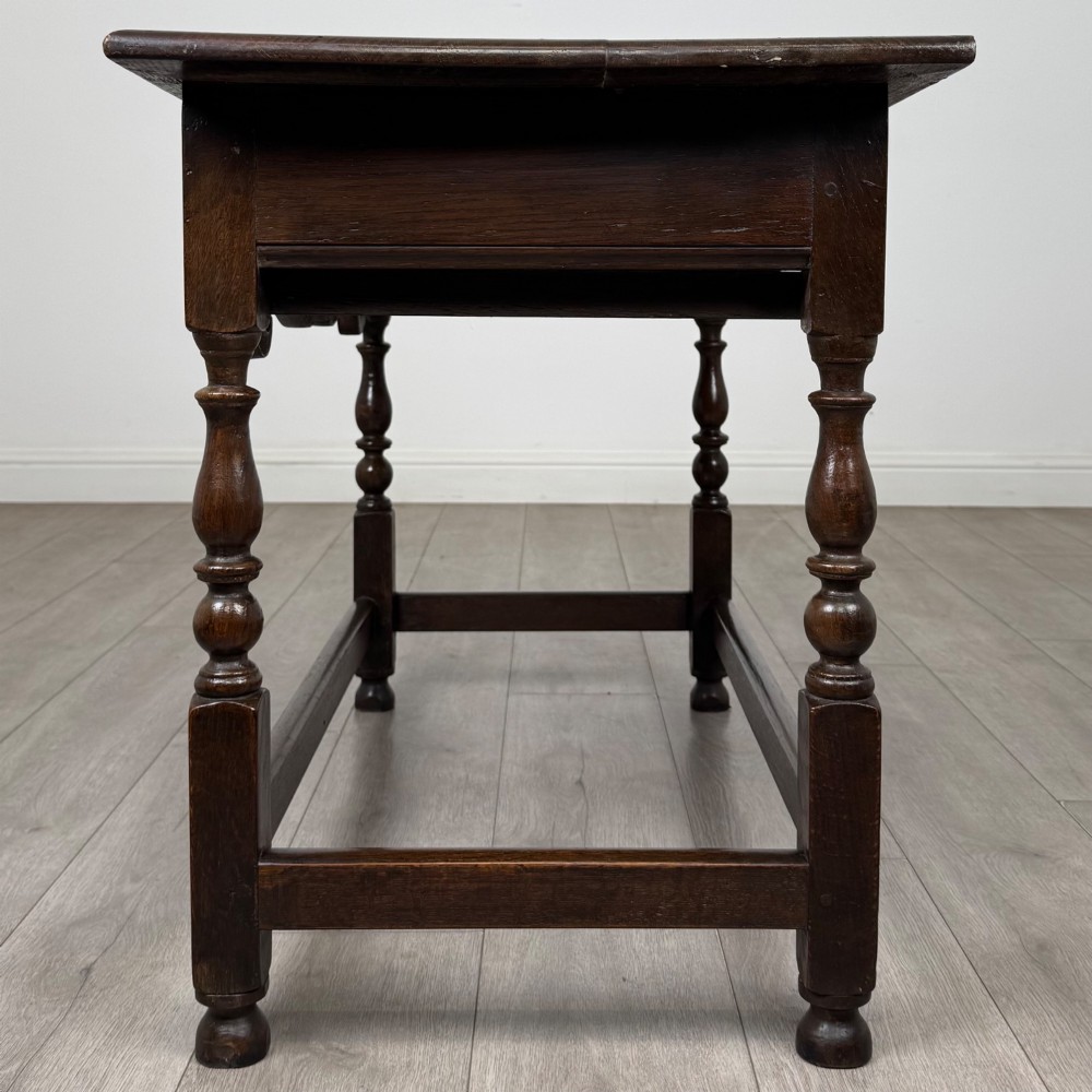 An 18th-century dark oak Georgian side table featuring two frieze drawers with brass handles, turned legs, a shaped apron, and a lower box stretcher. View III