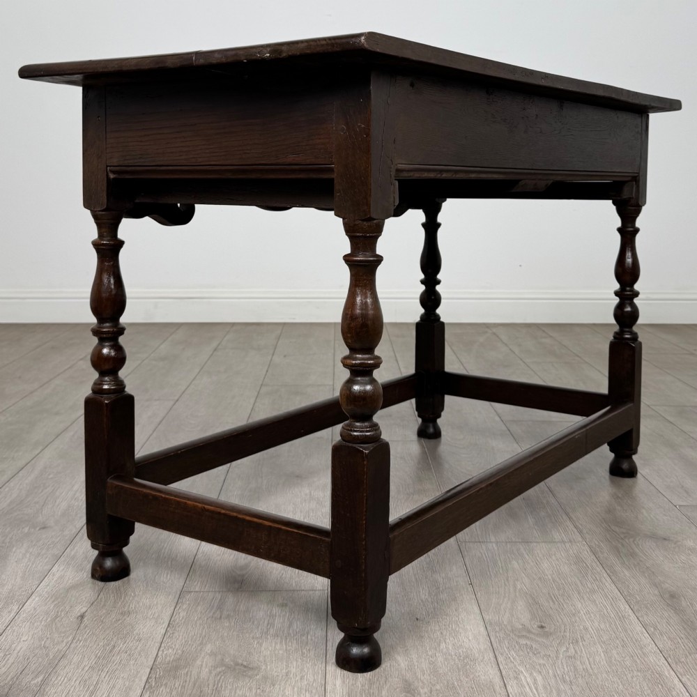 An 18th-century dark oak Georgian side table featuring two frieze drawers with brass handles, turned legs, a shaped apron, and a lower box stretcher. View IV