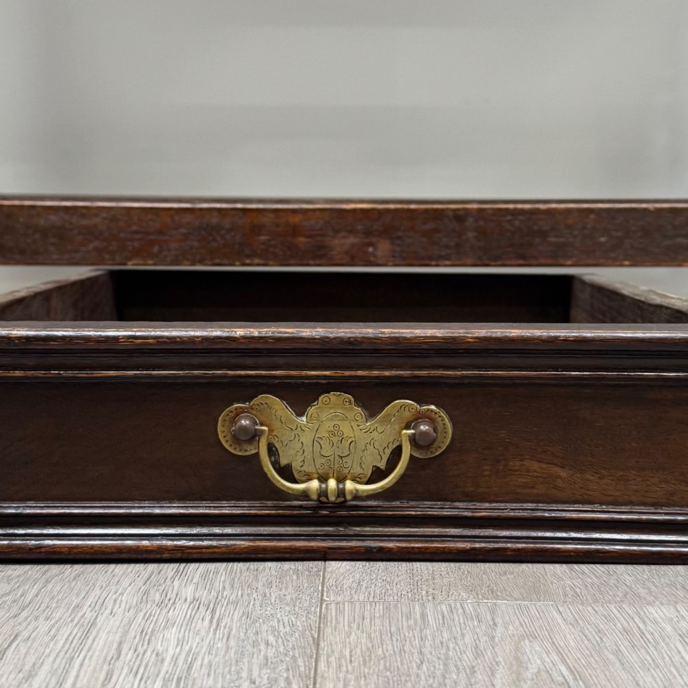 An 18th-century dark oak Georgian side table featuring two frieze drawers with brass handles, turned legs, a shaped apron, and a lower box stretcher. View XI