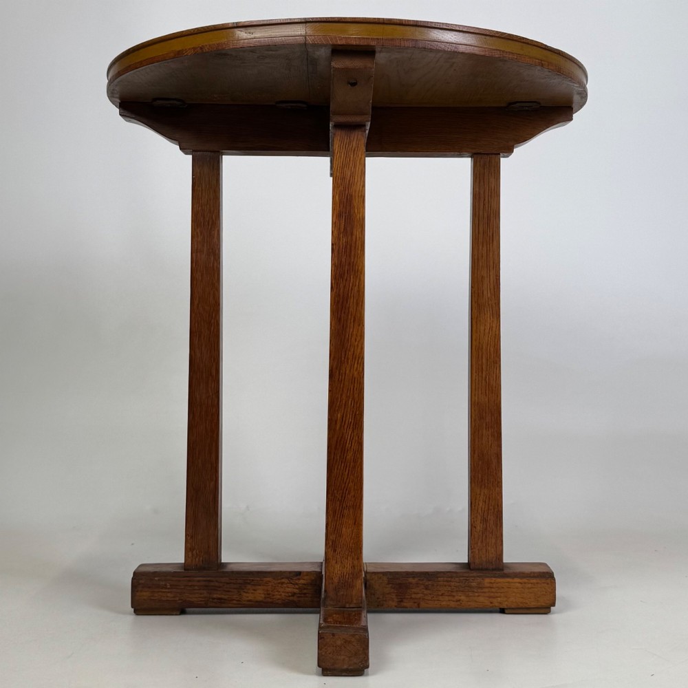 An early twentieth-century round oak side table featuring a circular top supported by straight legs and an X-frame cross base. View III