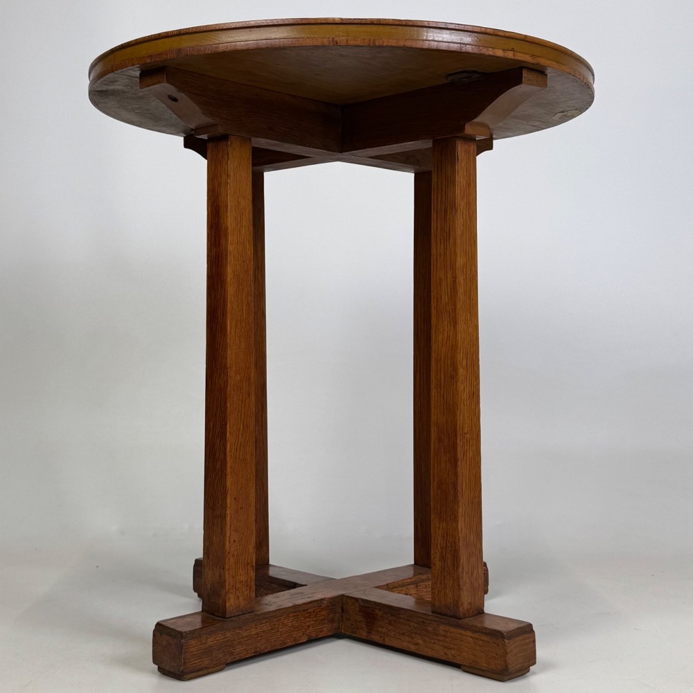 An early twentieth-century round oak side table featuring a circular top supported by straight legs and an X-frame cross base. View V