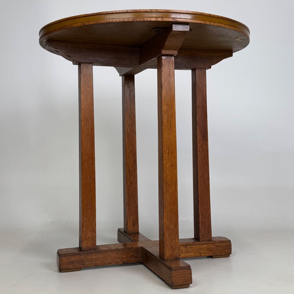 An early twentieth-century round oak side table featuring a circular top supported by straight legs and an X-frame cross base. View VI
