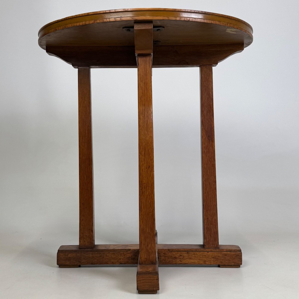 An early twentieth-century round oak side table featuring a circular top supported by straight legs and an X-frame cross base. View VII