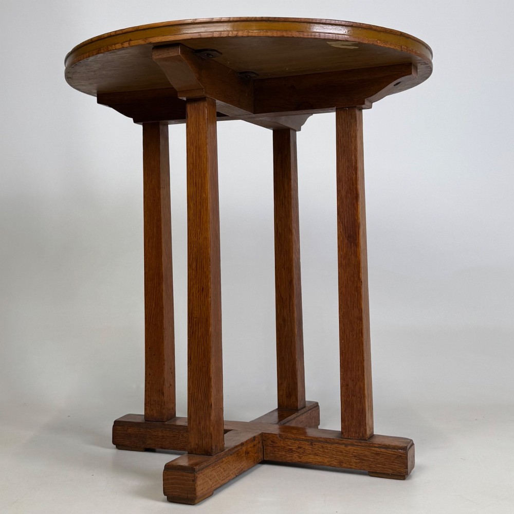 An early twentieth-century round oak side table featuring a circular top supported by straight legs and an X-frame cross base. View VIII