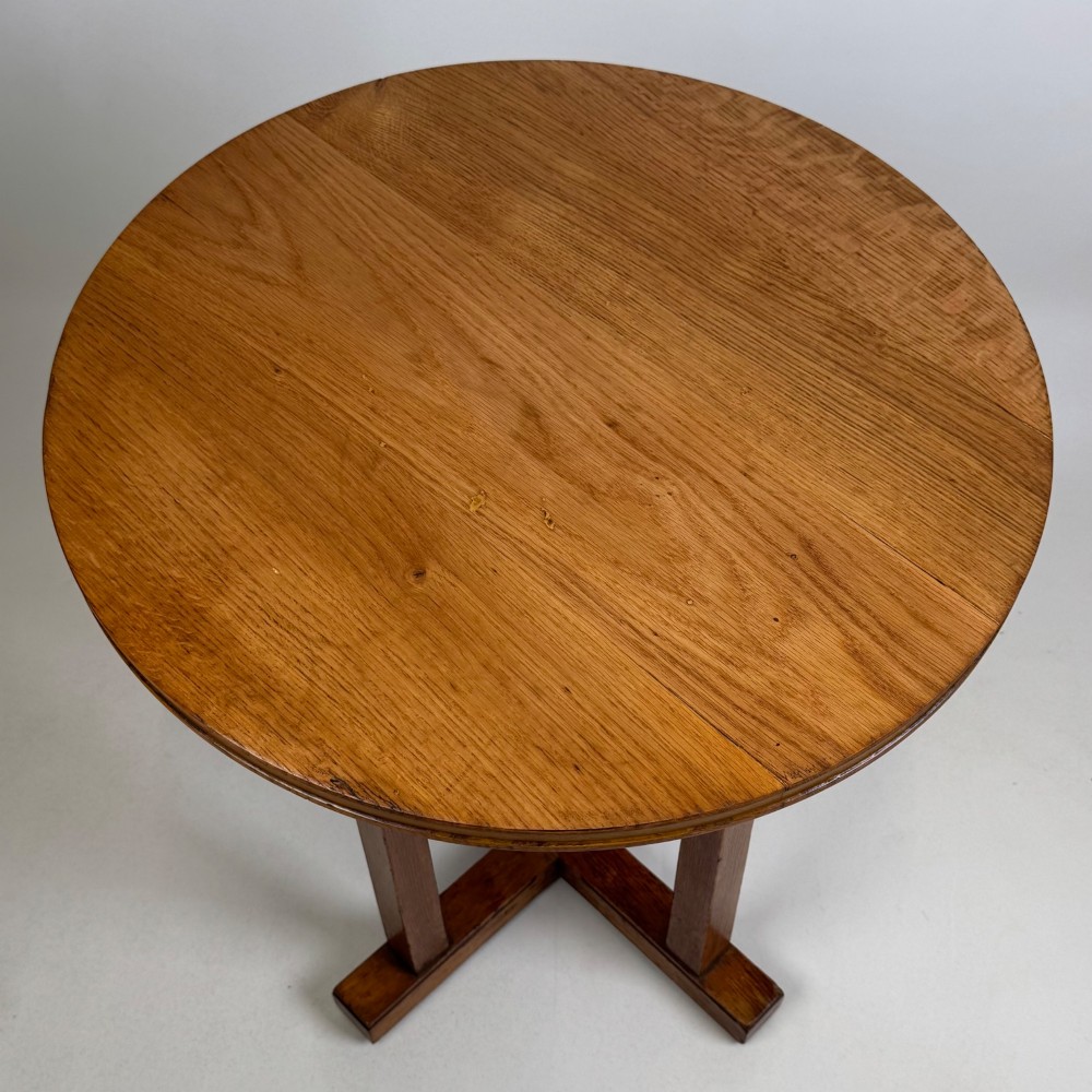 An early twentieth-century round oak side table featuring a circular top supported by straight legs and an X-frame cross base. View IX