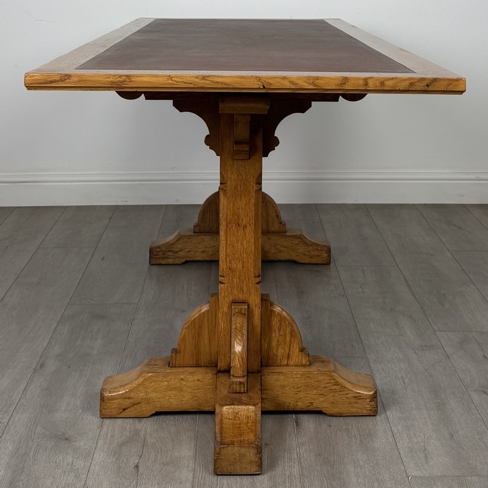 A large twentieth-century Arts and Crafts oak library table with an inset brown leather writing top resting on dual pedestal trestle supports. View III