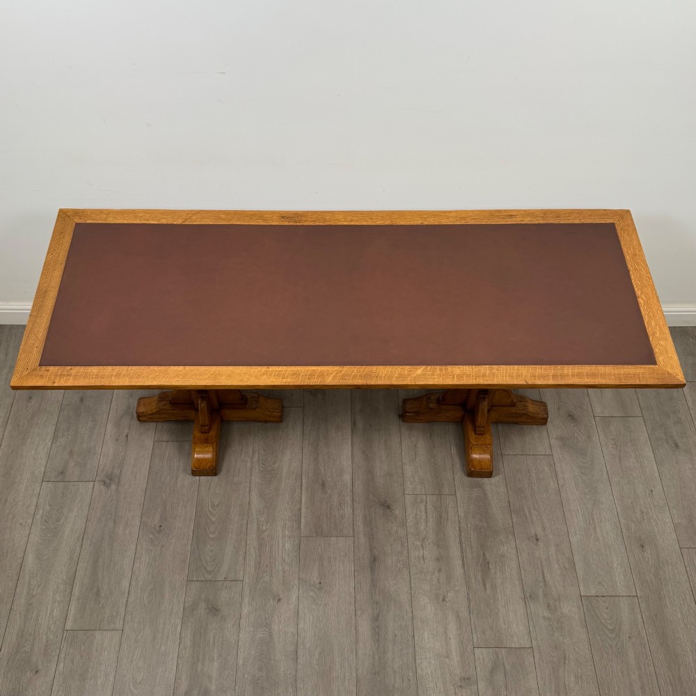 A large twentieth-century Arts and Crafts oak library table with an inset brown leather writing top resting on dual pedestal trestle supports. View IV