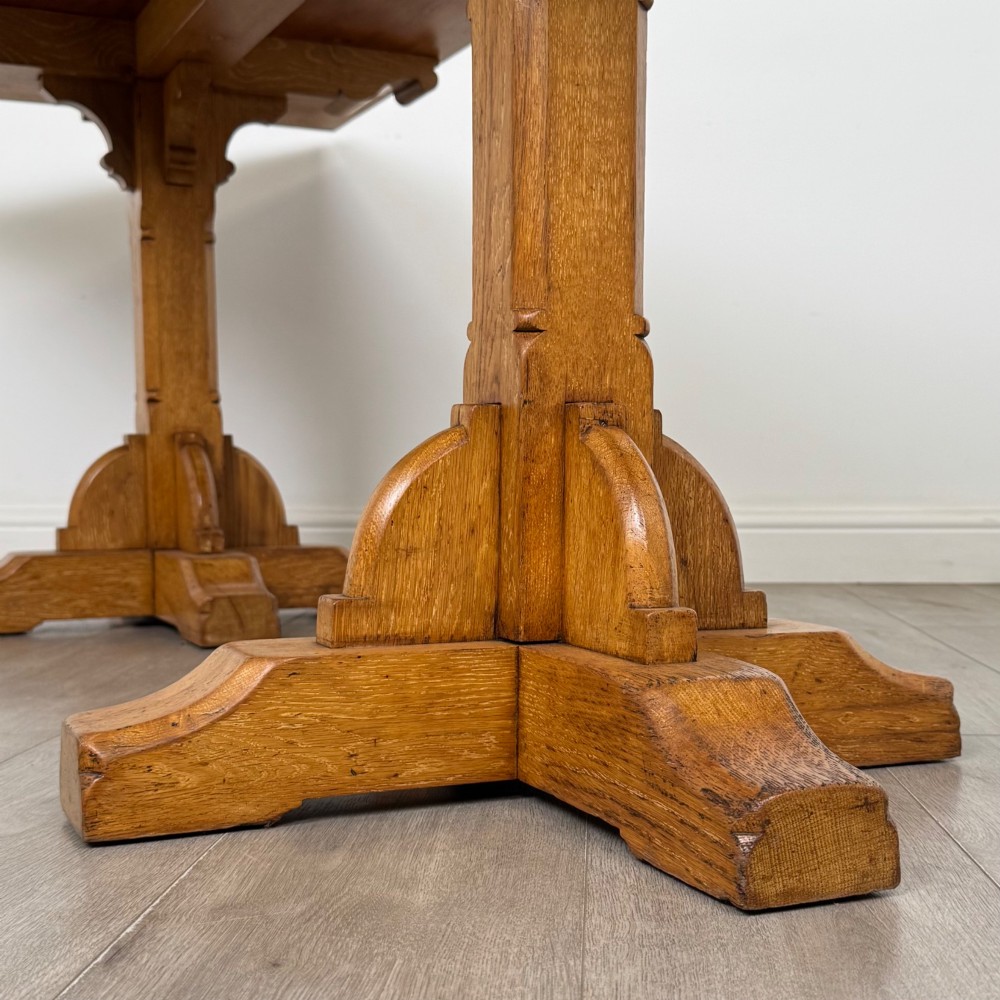 A large twentieth-century Arts and Crafts oak library table with an inset brown leather writing top resting on dual pedestal trestle supports. View VI