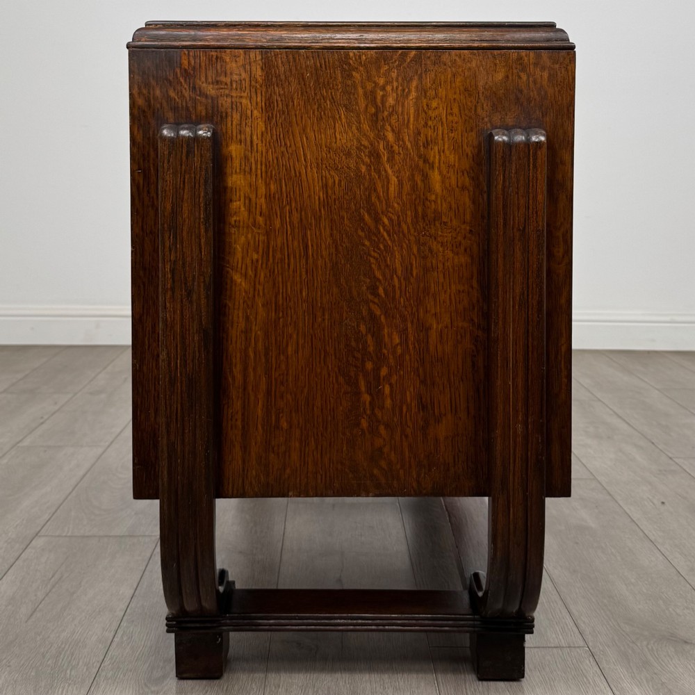 An Art Deco oak desk featuring two side cupboard pedestals supported by u-shaped curved legs and a central drawer. View IV