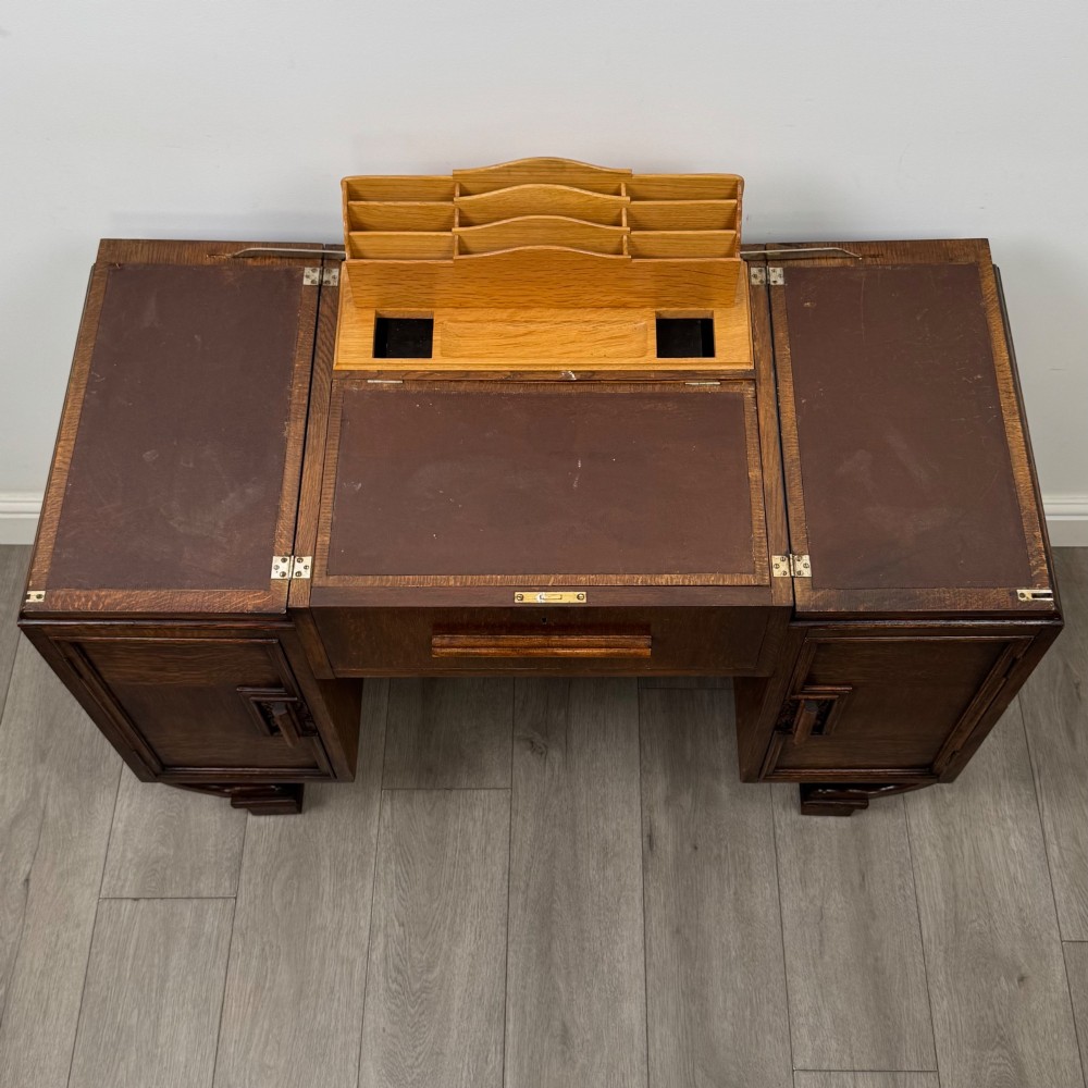 An Art Deco oak desk featuring two side cupboard pedestals supported by u-shaped curved legs and a central drawer. View XI