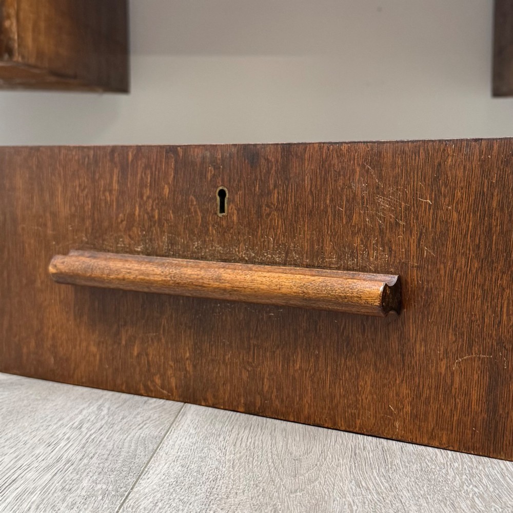 An Art Deco oak desk featuring two side cupboard pedestals supported by u-shaped curved legs and a central drawer. View XIII