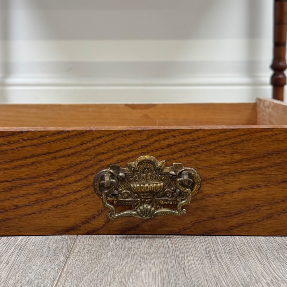 A 19th-century Victorian golden oak writing table featuring a single frieze drawer with decorative brass handles and ring-turned legs on castors. View XI