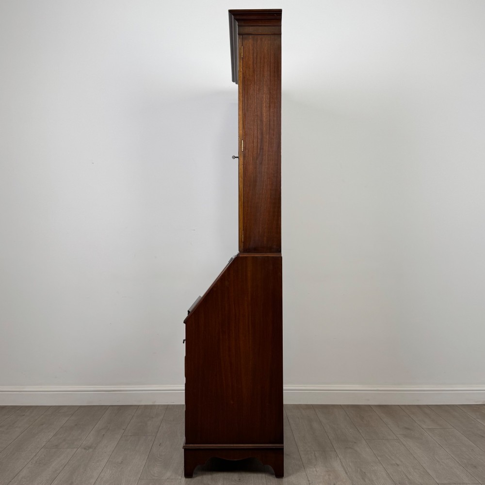 An antique mahogany bureau bookcase featuring two astragal glazed glass upper doors above a lower drop-front writing slope and four drawers. View V