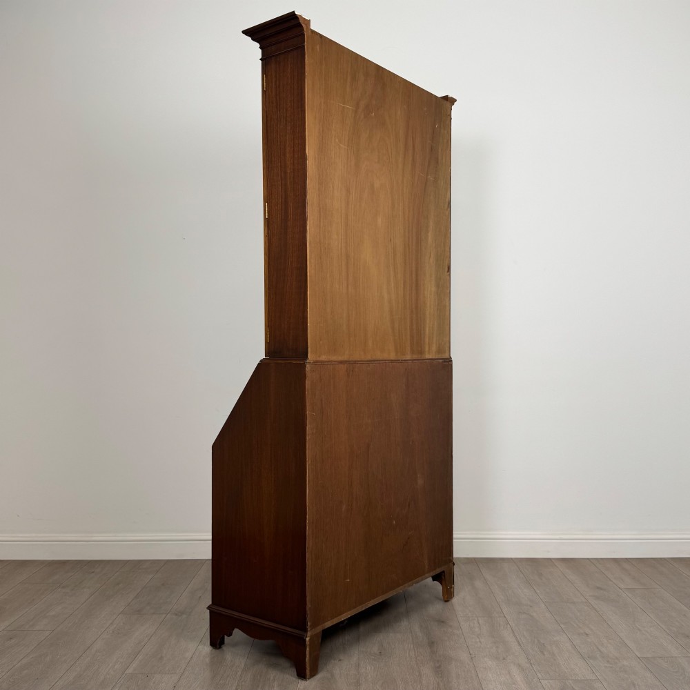 An antique mahogany bureau bookcase featuring two astragal glazed glass upper doors above a lower drop-front writing slope and four drawers. View VI