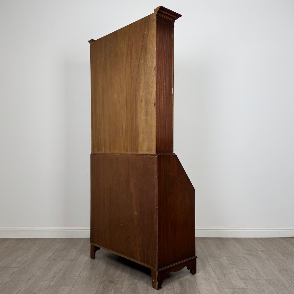 An antique mahogany bureau bookcase featuring two astragal glazed glass upper doors above a lower drop-front writing slope and four drawers. View VIII