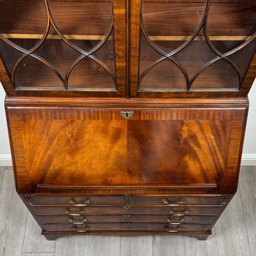 An antique mahogany bureau bookcase featuring two astragal glazed glass upper doors above a lower drop-front writing slope and four drawers. View XI