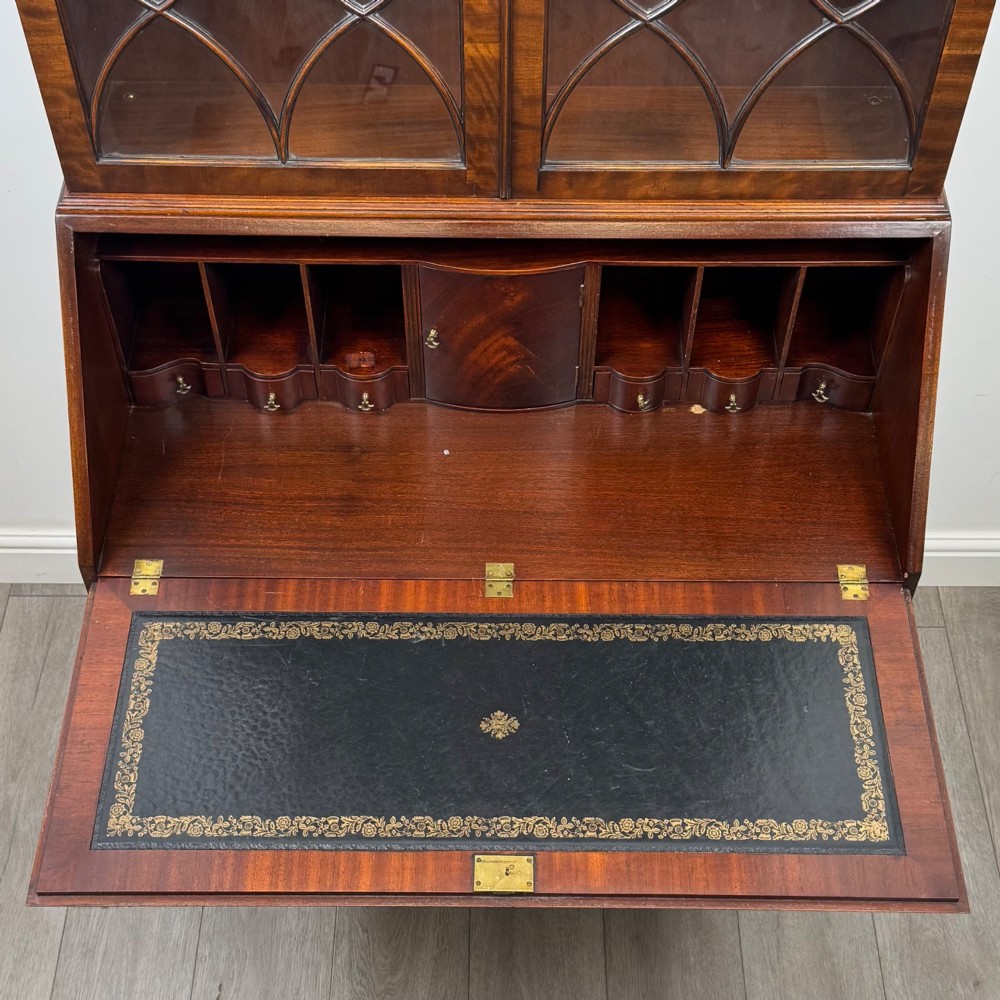 An antique mahogany bureau bookcase featuring two astragal glazed glass upper doors above a lower drop-front writing slope and four drawers. View XII