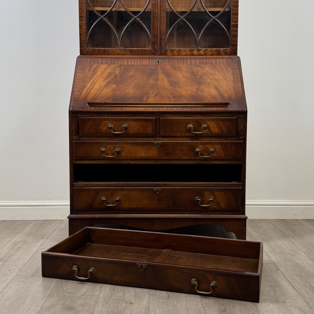 An antique mahogany bureau bookcase featuring two astragal glazed glass upper doors above a lower drop-front writing slope and four drawers. View XIII