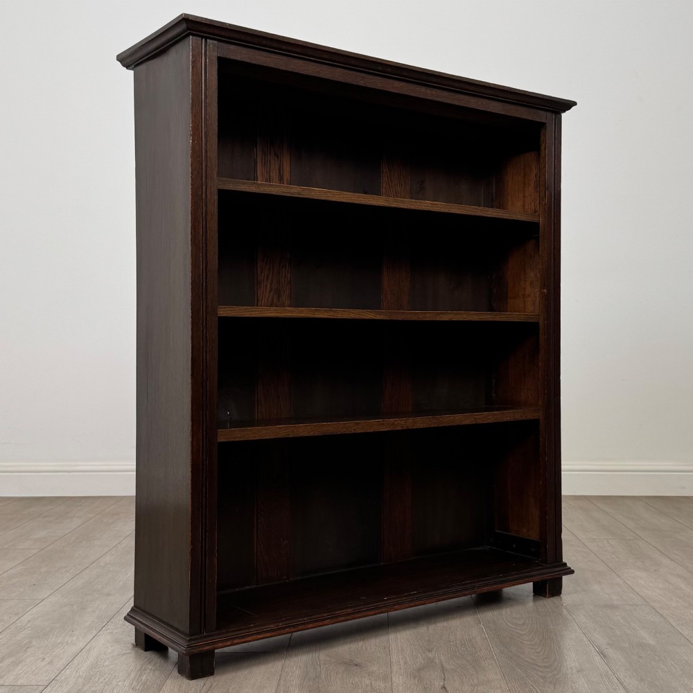 An Edwardian open oak bookcase with four wide shelves and dark timber finish. View IX