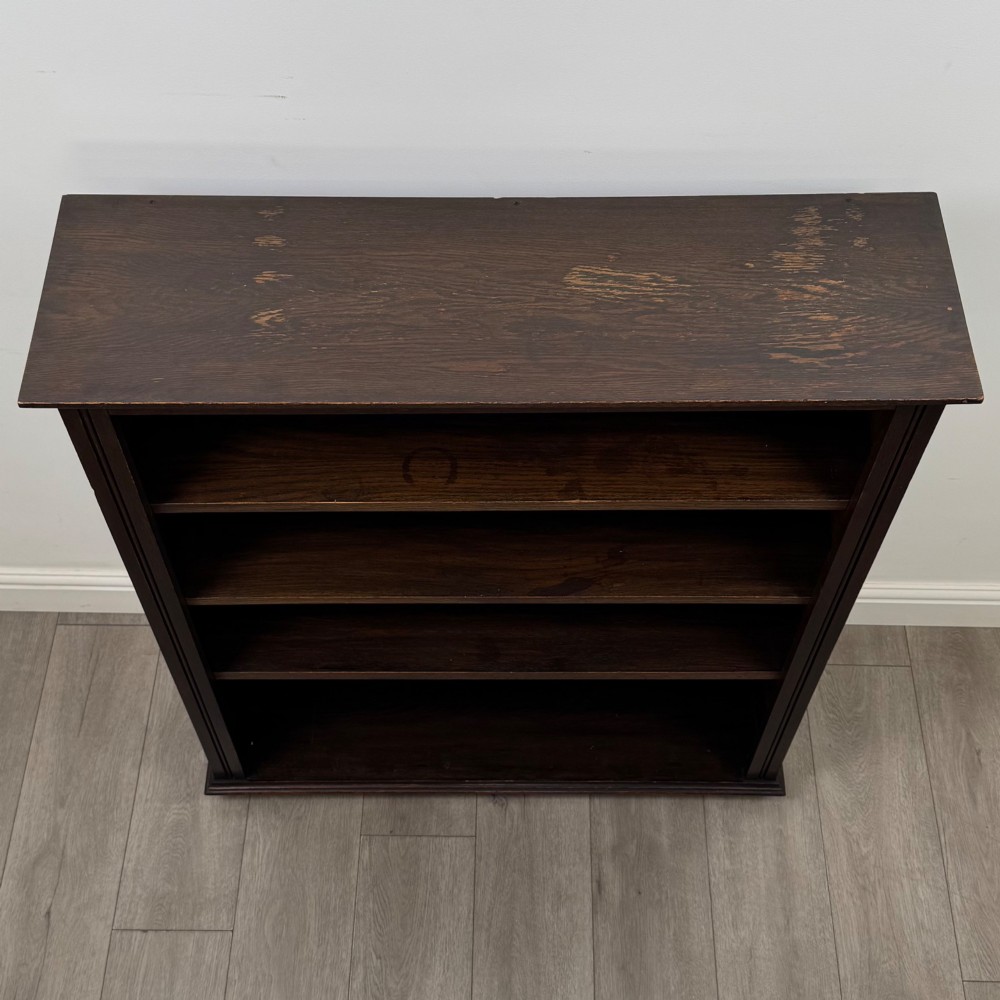 An Edwardian open oak bookcase with four wide shelves and dark timber finish. View X