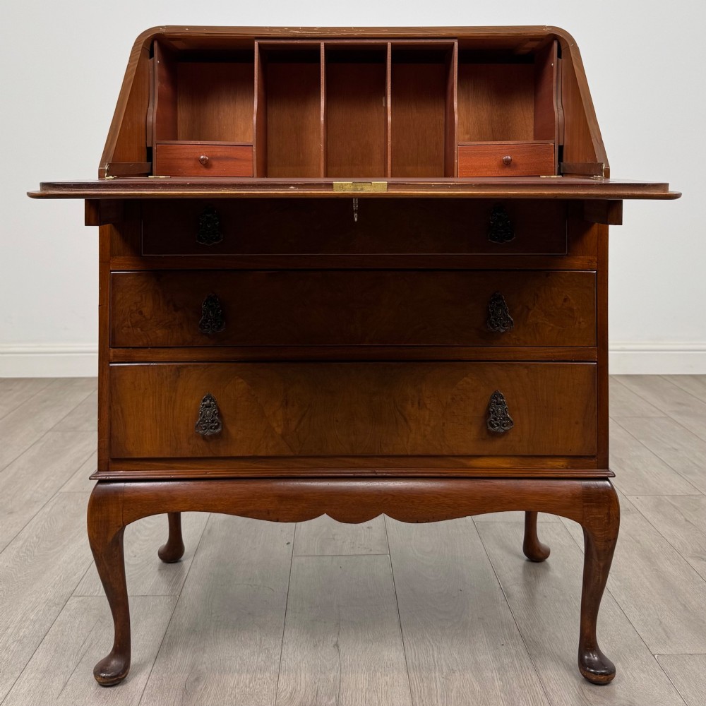 An Edwardian figured walnut writing bureau featuring a slant front above three drawers and carved cabriole legs. View II