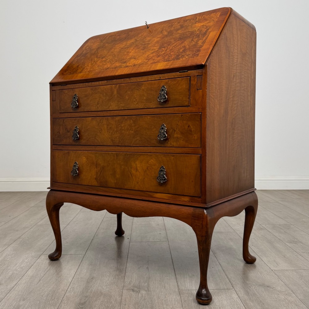 An Edwardian figured walnut writing bureau featuring a slant front above three drawers and carved cabriole legs. View III